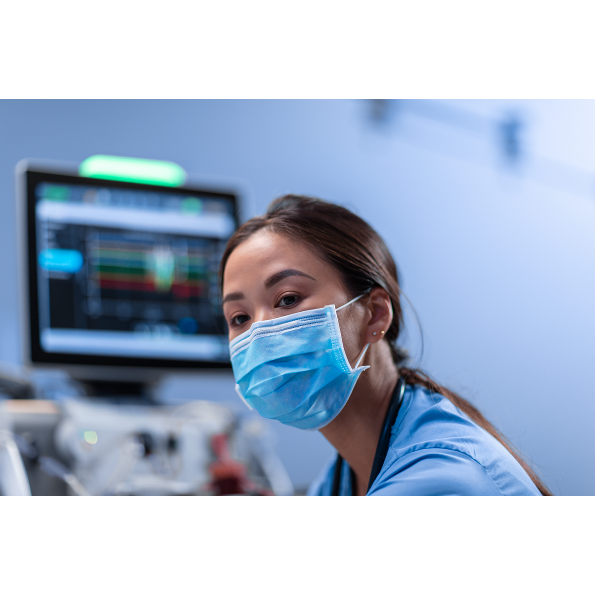 Nurse looks at patient with screen behind